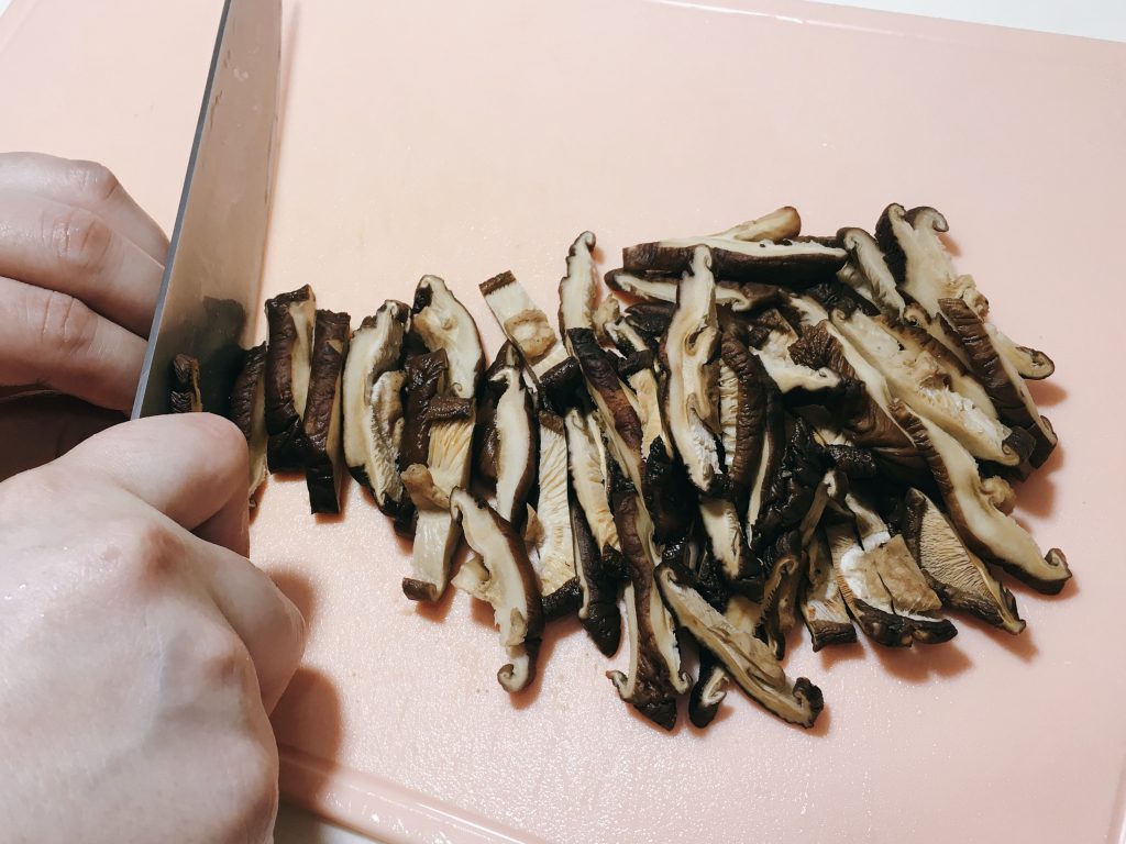 Slice the soaked mushrooms into strips.